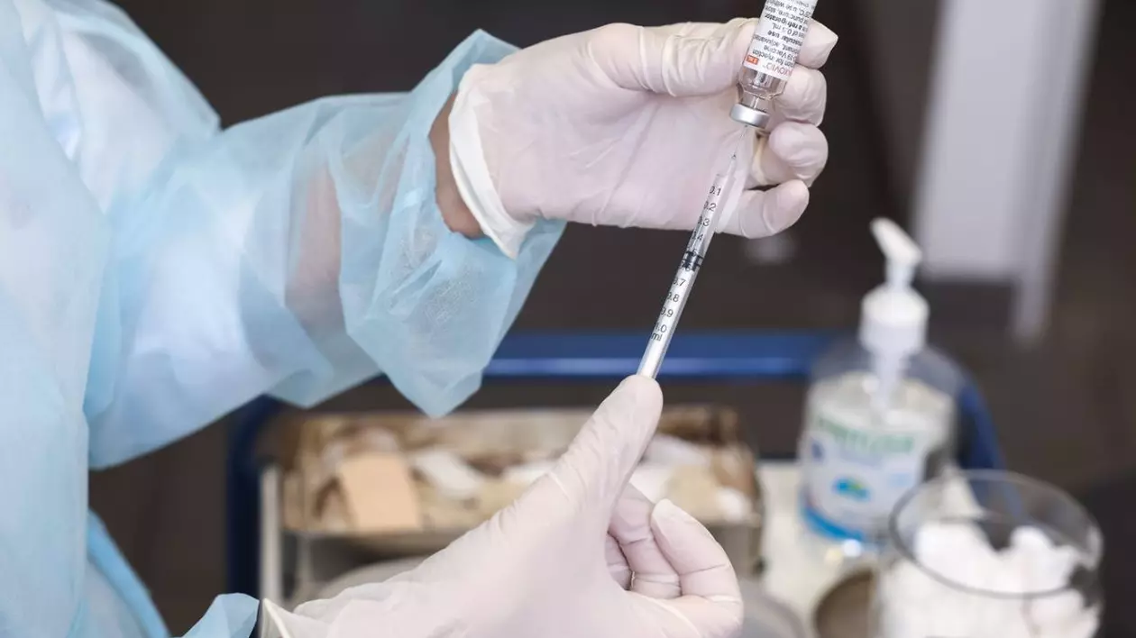 Asistent medical trage vaccin în seringă