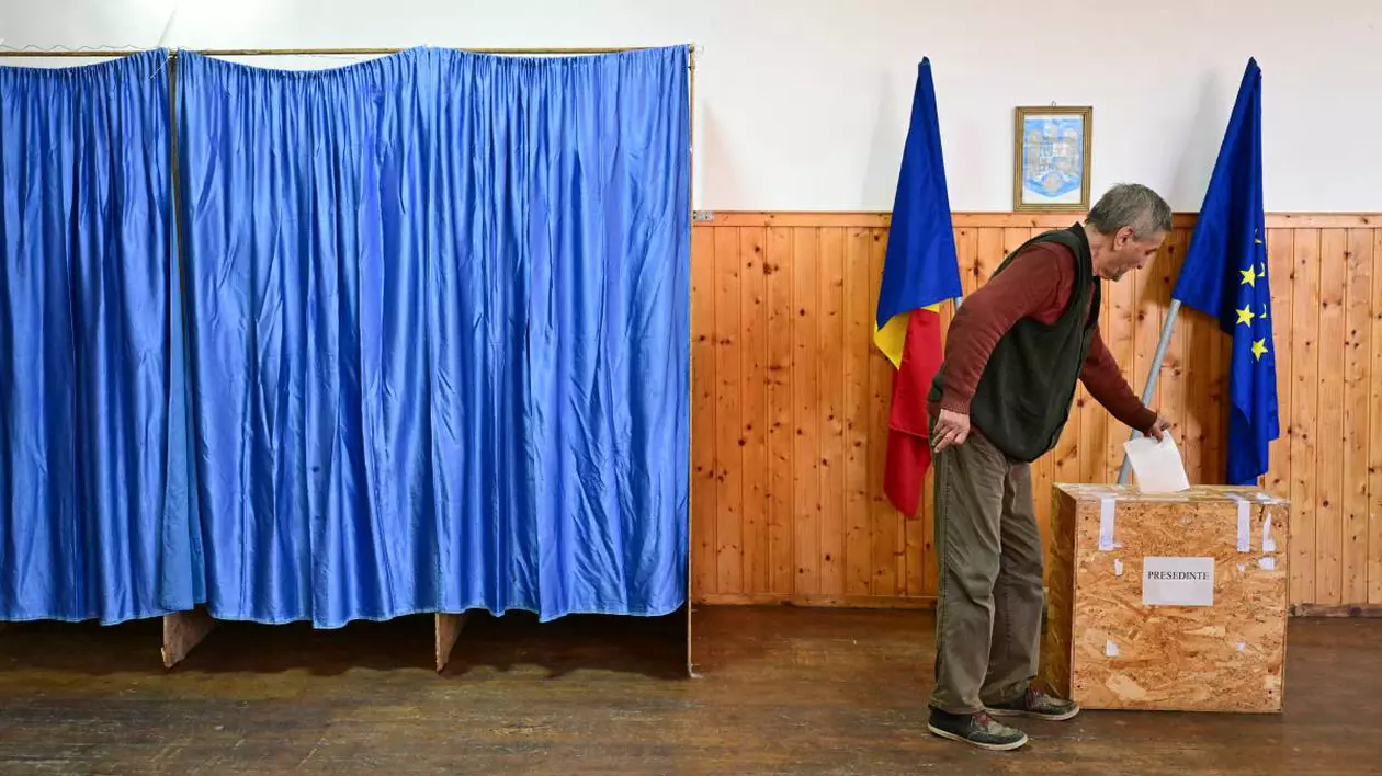 Un bărbat în vârstă, în timp ce se află în secția de vot și introduce buletinul ștampilat în urnă, la alegeri în România