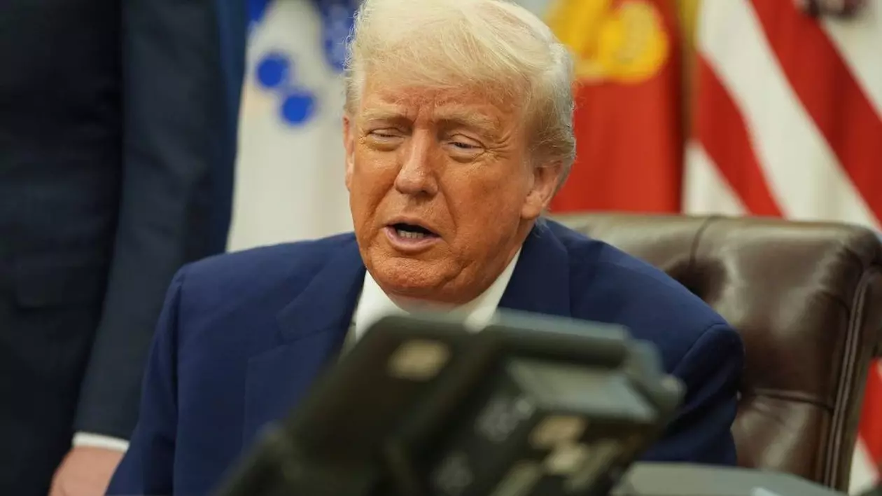Donald Trump în biroul de la Casa Albă, sta pe scaun, vorește la telefon pe difuzor