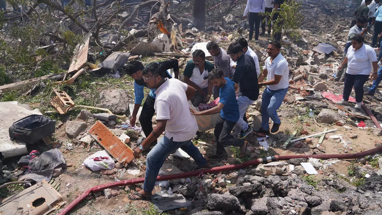 Salvatorii transportă cadavrul unei victime de la locul prăbușirii avionului Air India