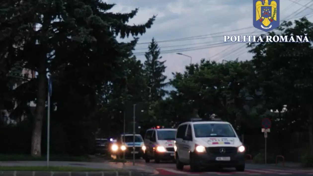 Imagini pe intuneric, masini de politie cu farurile aprinse, in misiune