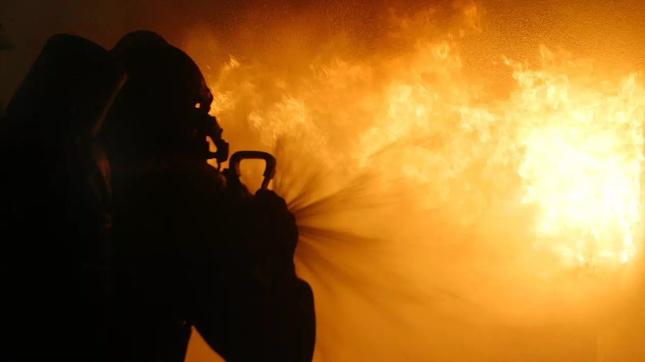 Imagine cu un pompier care încearcă să stingă un incendiu